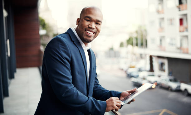 Portrait of a handsome young businessman using a digital tablet outside his office